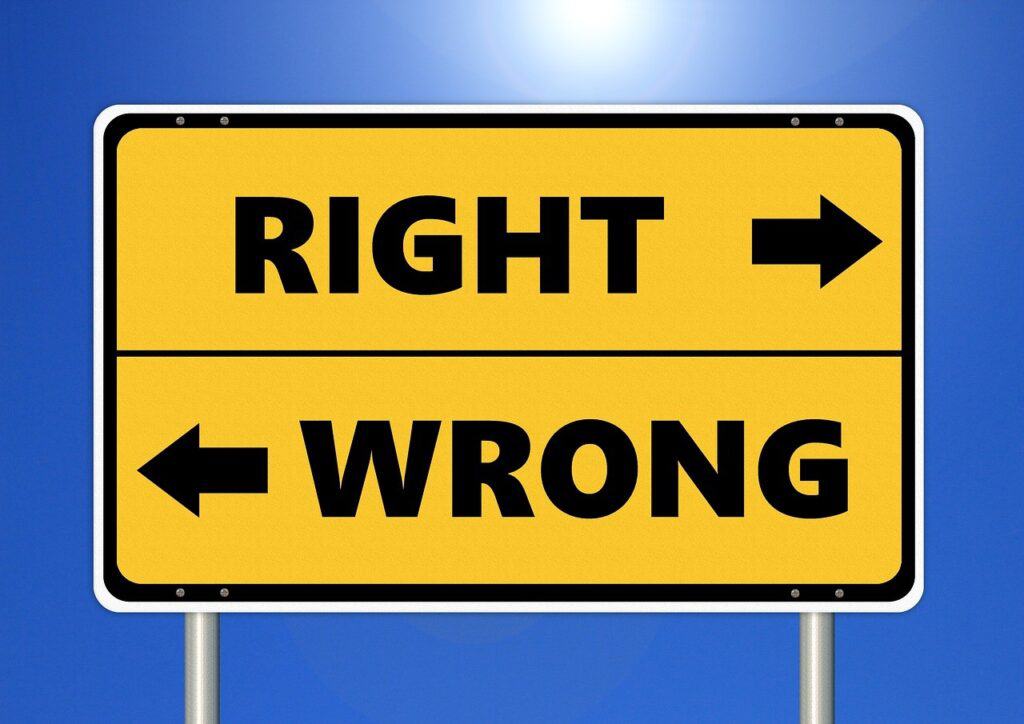 Yellow road sign. The top half of the sign says 'RIGHT' with an arrow pointing right. The bottom half says 'WRONG' with an arrow pointing left.