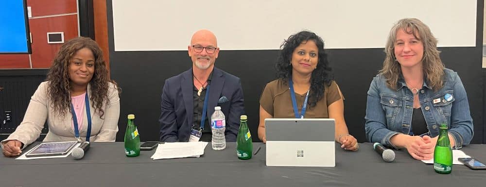 Photo of three women and one man sitting at a table