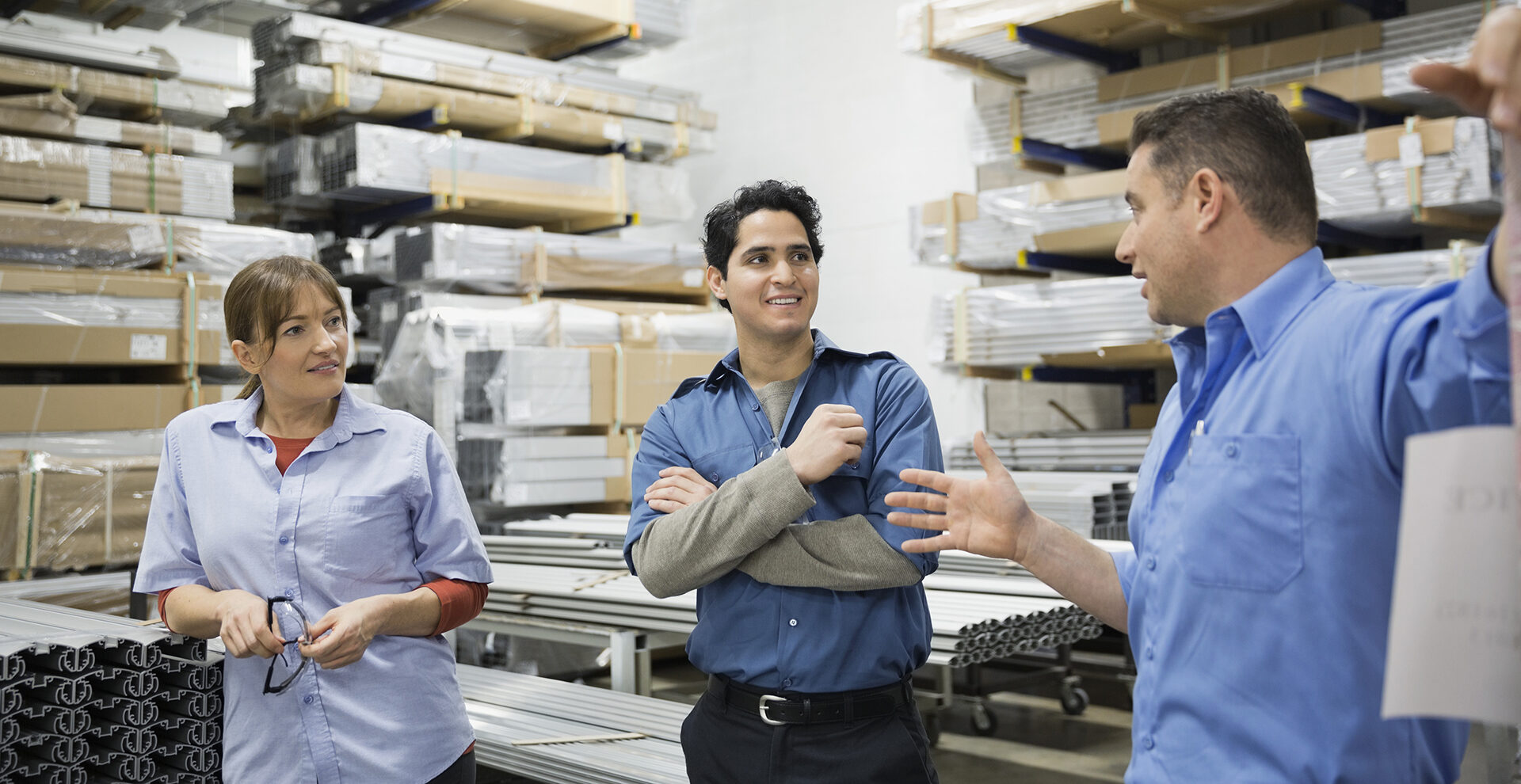 Worker explaining to colleagues in warehouse