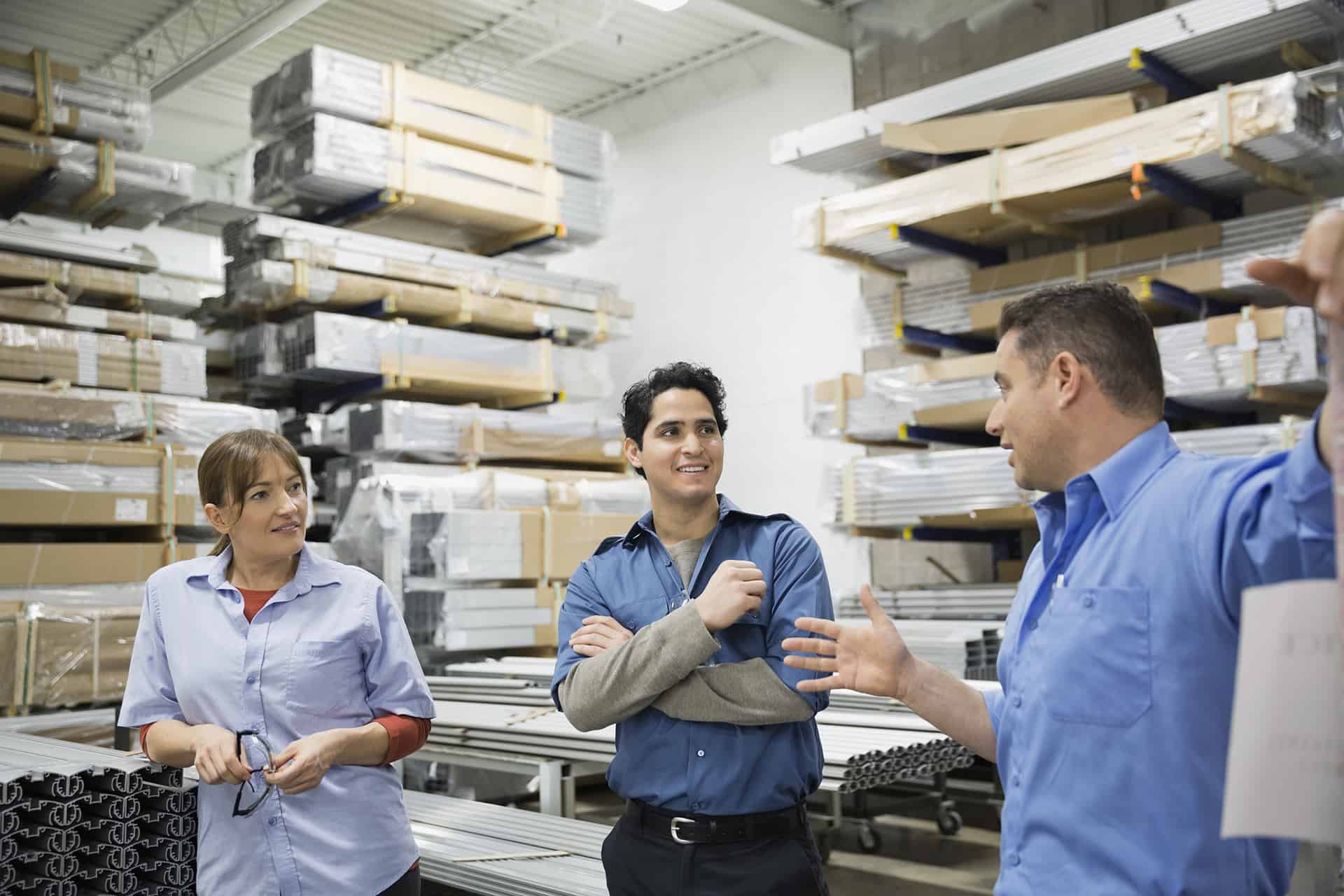 Worker explaining to colleagues in warehouse