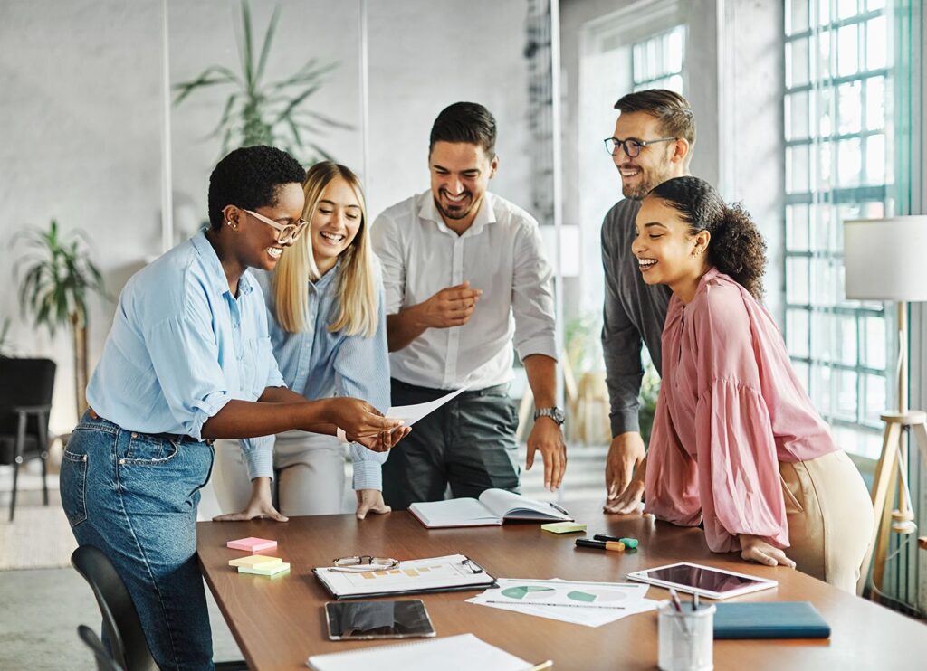 A group of people in a meeting room smiling.