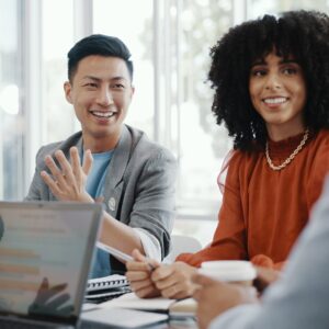 Dans une salle de réunion, un groupe de personnes d’identités raciales différentes s’assoient et discutent. L'image illustre l'importance d'une collaboration significative entre différentes personnes pour favoriser la diversité, l'équité et l'inclusion sur le lieu de travail.