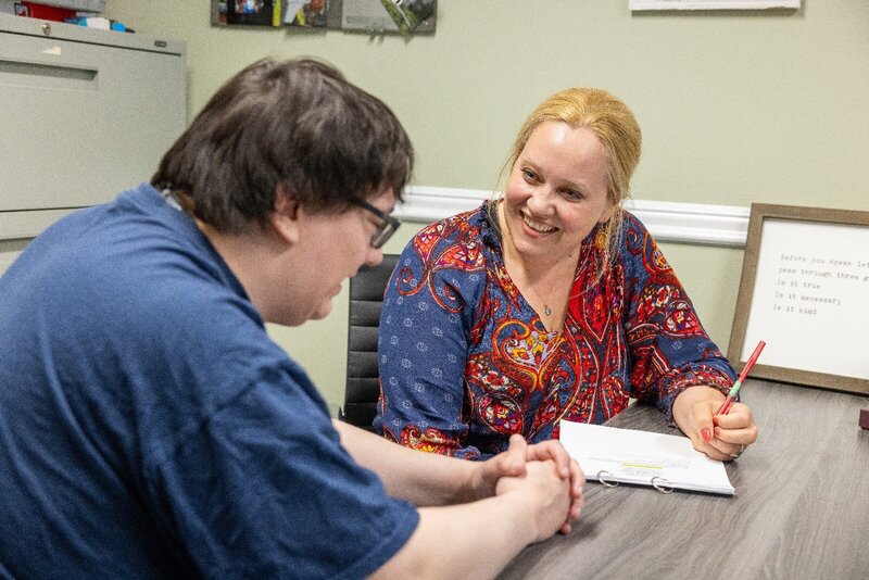 A vision/life coach works with a client in an office.