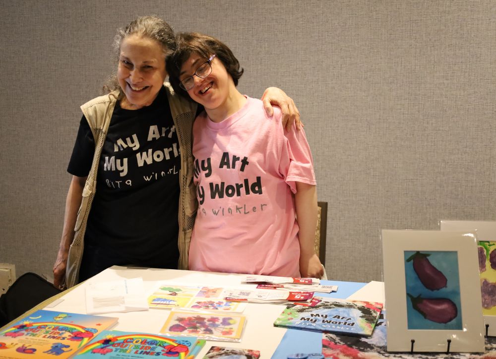 Rita Winkler (right) with her art at the Entrepreneurs Marketplace.