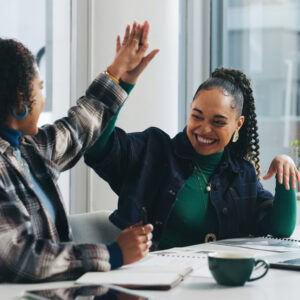 A career development practitioner and job seeker high five in celebration of an achievement.