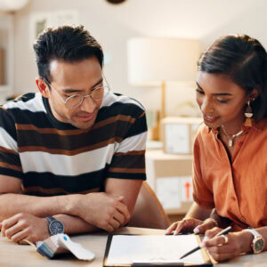 An employee and Job Coach sit at a table completing work together.