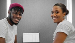 Two young workers with medium skin tone smiling